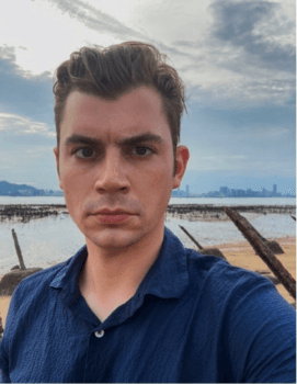 Adam Molon on a fortified beach on Lieyu, a Taiwan-governed island in Quemoy, with the Chinese city of Xiamen visible across the water. (Courtesy of Adam Molon)