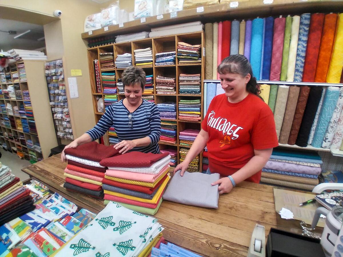Wertz Variety Store owner Georgia Wertz-Woolery (L) told the Epoch Times on Dec. 7 that the 94-year-old store has not received artificial floral items such as Poinsettias, Holly and plastic berries for decorative purposes. Store employee Anna Pratt (R) is organizing fabric in the store with Wertz-Woolery. (Michael Sakal/Epoch Times)