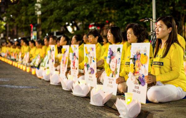 Falun Gong practitioners hold a candlelight vigil in front of the Chinese Consulate in Toronto on July 13, 2019, holding photos of fellow adherents who had died as a result of persecution in China. (Handout)