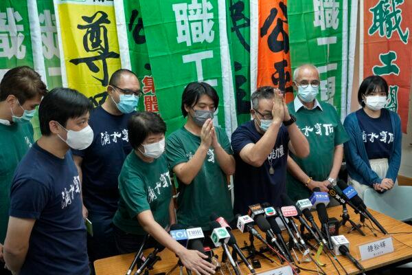 Hong Kong Confederation of Trade Unions President Joe Wong Nai-yuen, third from right, gestures while posing for a photo with other members before a news conference on the possibility of disbandment in Hong Kong, on Sept. 19, 2021. (Vincent Yu/AP Photo)