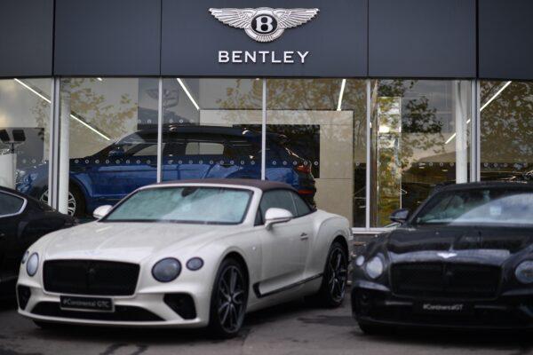 The sign of the luxury car maker Bentley is pictured behind cars on the forecourt, outside a garage in Tunbridge Wells, southeast of London, on Nov. 6, 2020. (Ben Stansall/AFP via Getty Images)