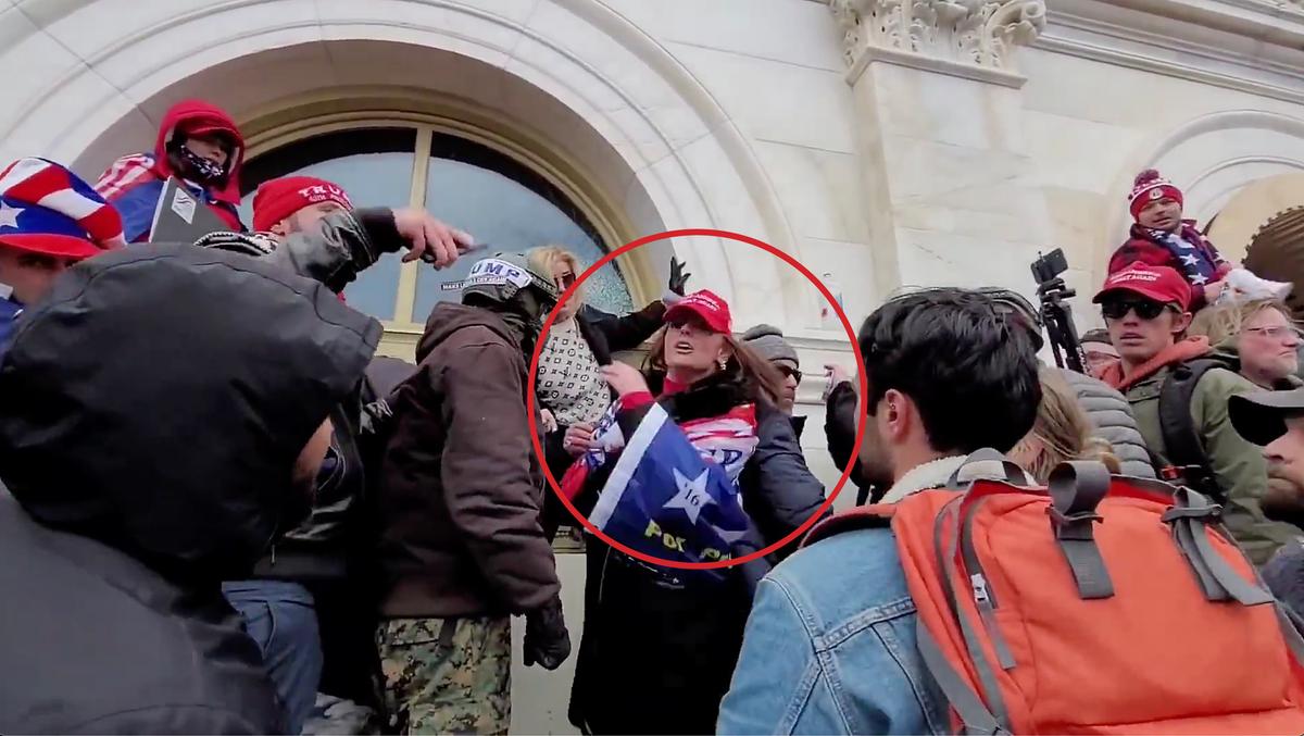 Victoria C. White of Rochester, Minn., chastises an unidentified man for smashing a U.S. Capitol window on Jan. 6, 2021. She was later assaulted by police in the adjacent West Terrace tunnel, her attorney says. (Screen Capture/via The Epoch Times)