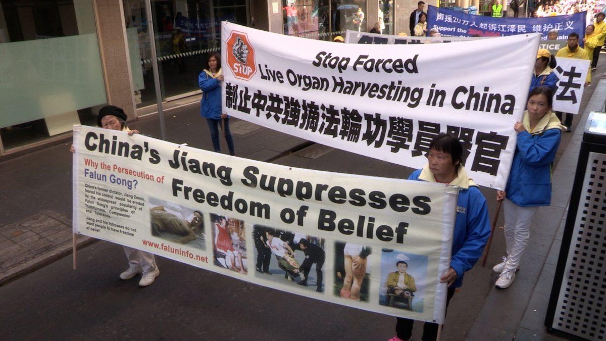 Falun Gong practitioners holding banners raising awareness about forced organ harvesting and bringing Jiang Zemin, the former CCP leader, to justice, in Melbourne, Australia, on July 14, 2018. (Daniel Cameron/NTD)