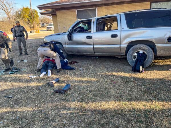 Law enforcement and emergency personnel aid the driver and passenger of a truck that rolled and hit a house during a high-speed chase in Brackettville, Texas, on Feb. 18, 2022. (Courtesy of Kinney County Sheriff’s Office)