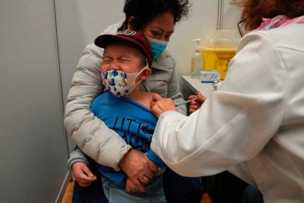 A boy receives a dose of China's Sinovac COVID-19 vaccine at a community vaccination center in Hong Kong on Feb. 25, 2022. (Kin Cheung/AP Photo)
