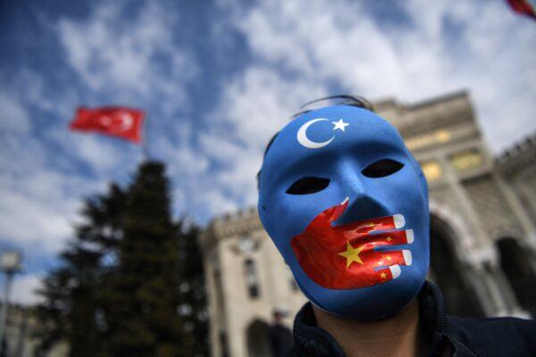 A demonstrator wearing a mask painted with the colors of the East Turkestan flag takes part in a protest by supporters of the Uighur minority at Beyazid Square in Istanbul on April 1, 2021. (Ozan Kose/AFP via Getty Images)
