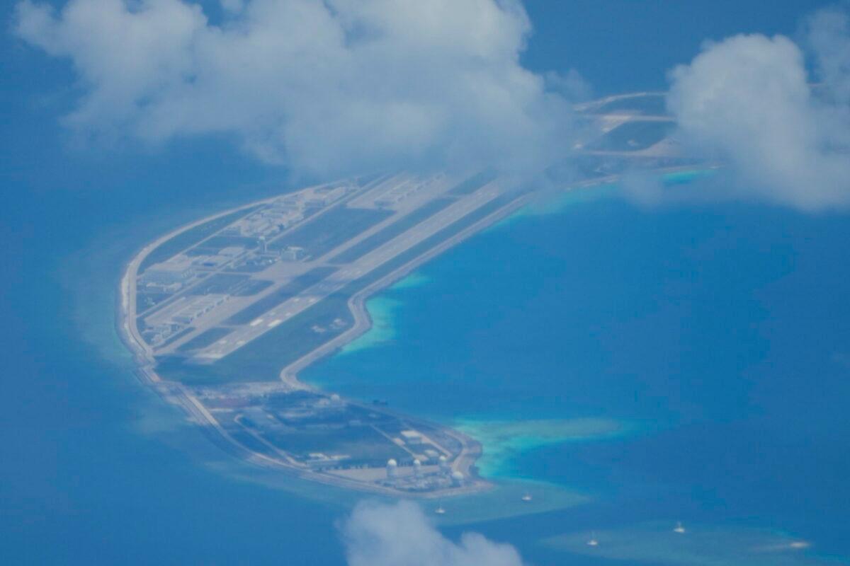 An airstrip made by China is seen beside structures and buildings at the man-made island on Mischief Reef at the Spratlys group of islands in the South China Sea are seen on Sunday March 20, 2022. (AP Photo/Aaron Favila)