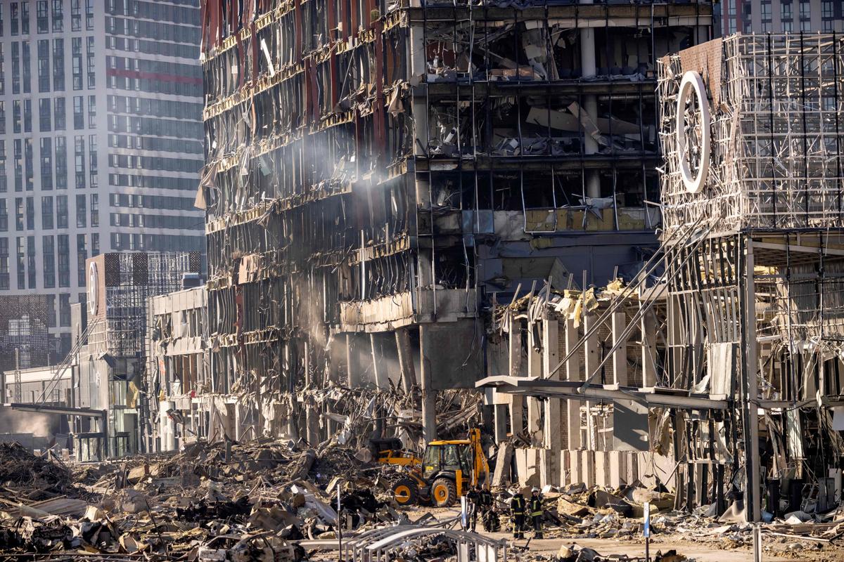 Ukrainian firefighters work amid the rubble of the Retroville shopping mall a day after it was shelled by Russian forces in a residential district in the northwest of the Ukrainian capital of Kyiv on March 21, 2022. (Fadel Senna/AFP via Getty Images)