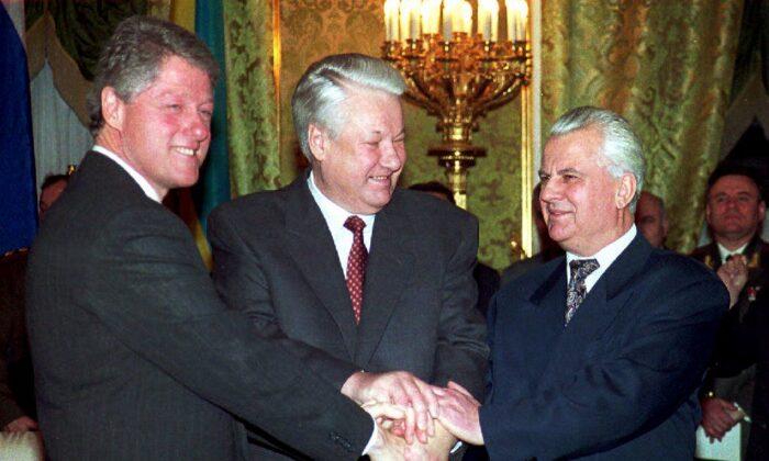 U.S. President Bill Clinton (L), Russian President Boris Yeltsin (C), and Ukrainian counterpart Leonid M. Kravchuk (R) join hands after signing the nuclear disarmament agreement in the Kremlin in Moscow, Russia, on Jan. 14, 1994. Under the agreement, Ukraine, the world's third-largest nuclear power, said it would turn all of its strategic nuclear arms over to Russia for destruction. (Sergei Supinsky/AFP via Getty Images)