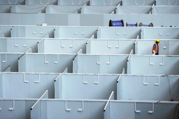 A worker setting up a makeshift hospital in Shanghai that will be used for COVID-19 patients, on April 7, 2022. (CNS/AFP via Getty Images)