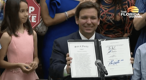 Florida Gov. Ron DeSantis signs the "Stop Woke Bill" in Hialeah Gardens, Fla., on April 22, 2022. (The Florida Channel/Screenshot via The Epoch Times)
