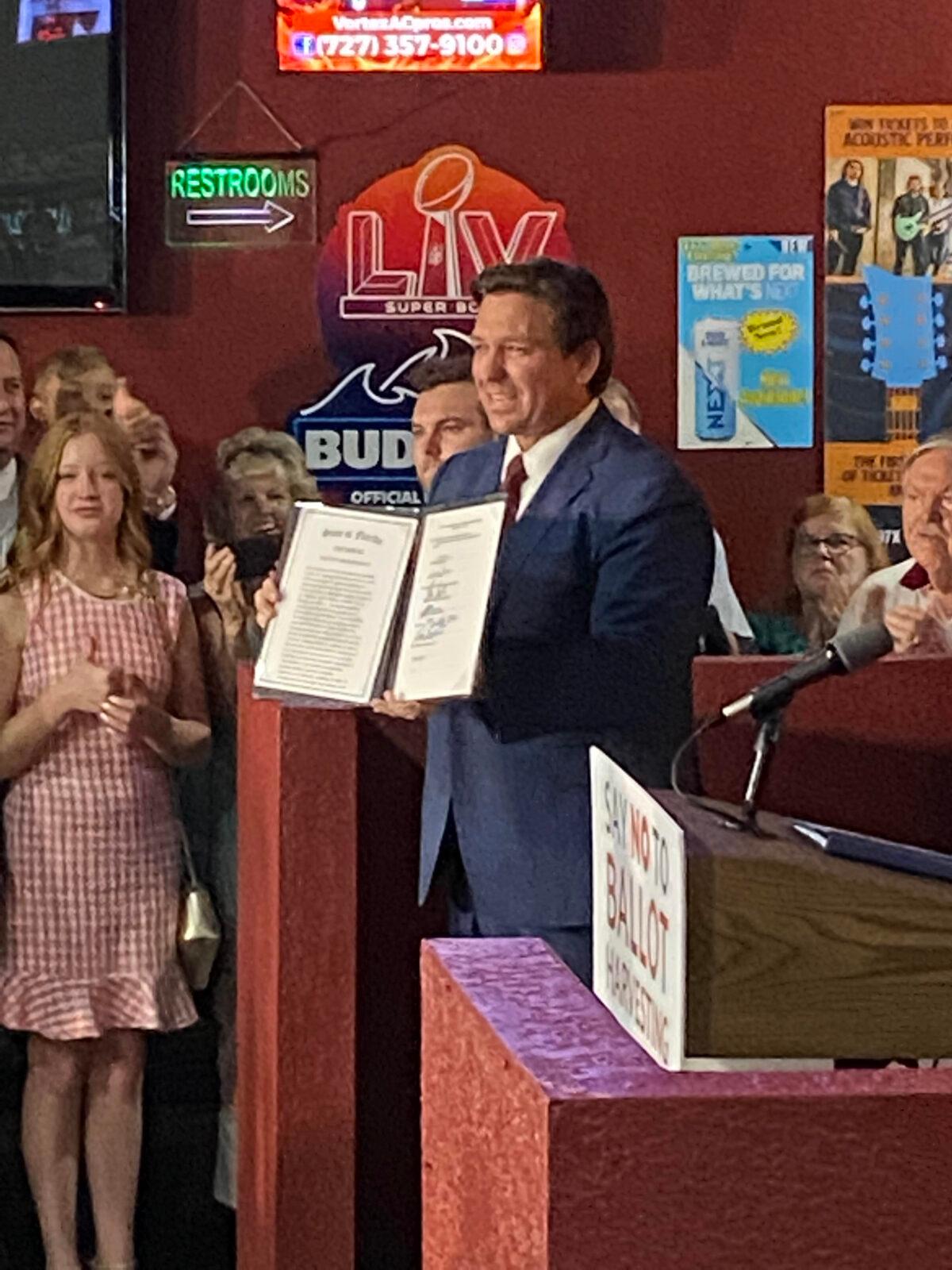Florida Gov. Ron DeSantis displays the newly signed election integrity law that creates the nation's first office to investigate election fraud at a press conference in Spring Hill, Fla., on April 25, 2022. (Patricia Tolson/The Epoch Times)