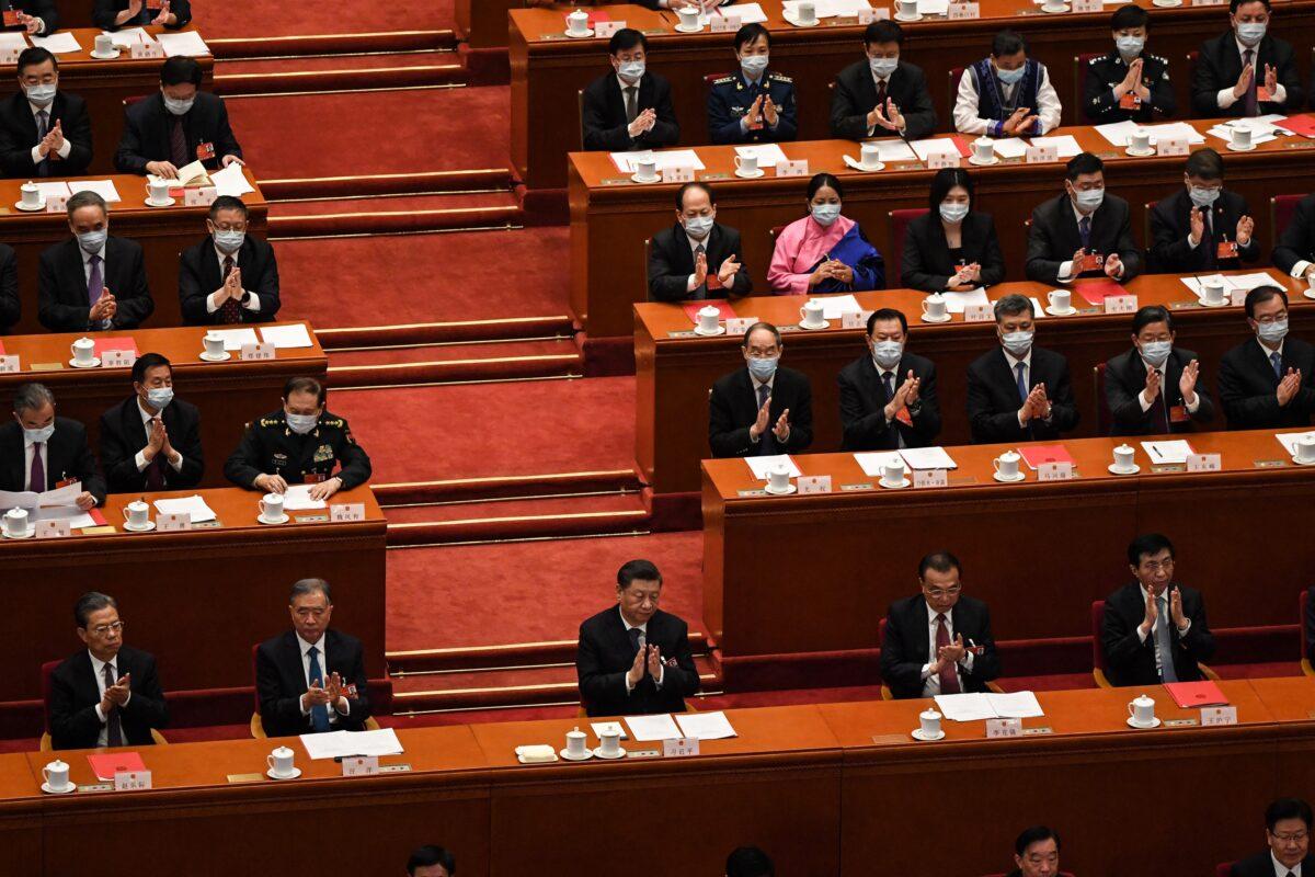 Chinese Communist Party leader Xi Jinping and other leaders applaud during the closing session of the rubber-stamp legislature’s conference at the Great Hall of the People in Beijing on March 11, 2022. (Leo Ramirez/AFP via Getty Images)