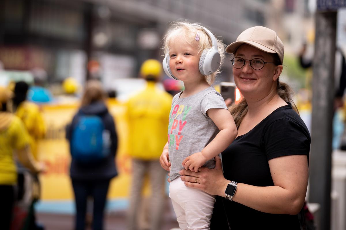 Pedestrians watch as Falun Gong practitioners take part in a parade marking the 30th anniversary of its introduction to the public, in Manhattan, New York, on May 13, 2022. (Samira Bouaou/The Epoch Times)