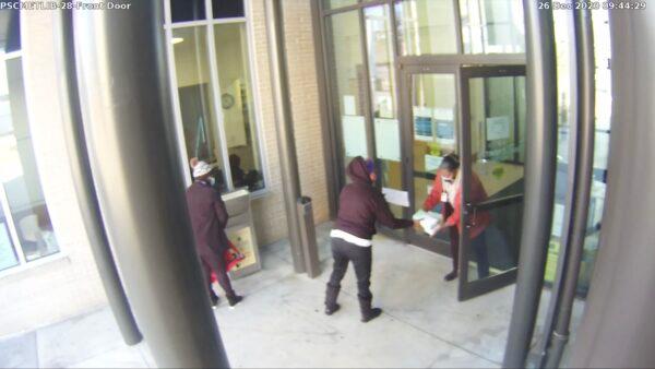 A still frame from surveillance footage of a ballot dropbox at a library in Atlanta. True the Vote officially has asked Georgia officials to investigate the circumstances. Video seems to show ballots being passed between an election worker and an unknown library staffer. (Courtesy of True the Vote)