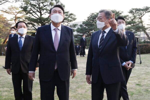 South Korean President-elect Yoon Suk Yeol (2nd L) and South Korean President Moon Jae-in (2nd R) talk before their meeting at the presidential Blue House in Seoul, South Korea, on March 8, 2022. (Kim Jin-ah/Newsis via AP)