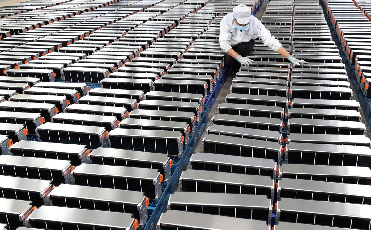 A worker with car batteries at a factory for Xinwangda Electric Vehicle Battery Co. Ltd, which makes lithium batteries for electric cars and other uses, in Nanjing in China's eastern Jiangsu Province, on March 12, 2021. (STR/AFP via Getty Images)