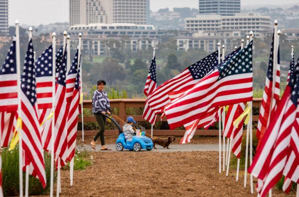 People walk through a display of 1776 American flags displayed in Castaways Park in Newport Beach, Calif., on May 23, 2022. (John Fredricks/The Epoch Times)