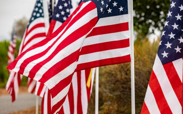People walk through a display of 1776 American flags displayed in Castaways Park in Newport Beach, Calif., on May 23, 2022. (John Fredricks/The Epoch Times)