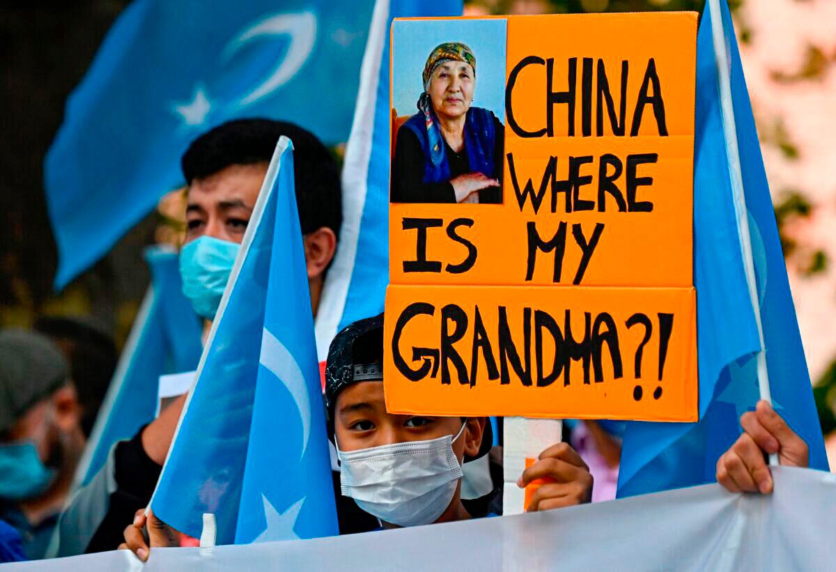 A young Uyghur activist holds up a poster that reads "China where is my grandma?!" during a demonstration outside the Foreign Office in Berlin, where the Chinese foreign minister was expected to hold talks with his German counterpart on Sept. 1, 2020. (Tobias Schwarz/AFP via Getty Images)