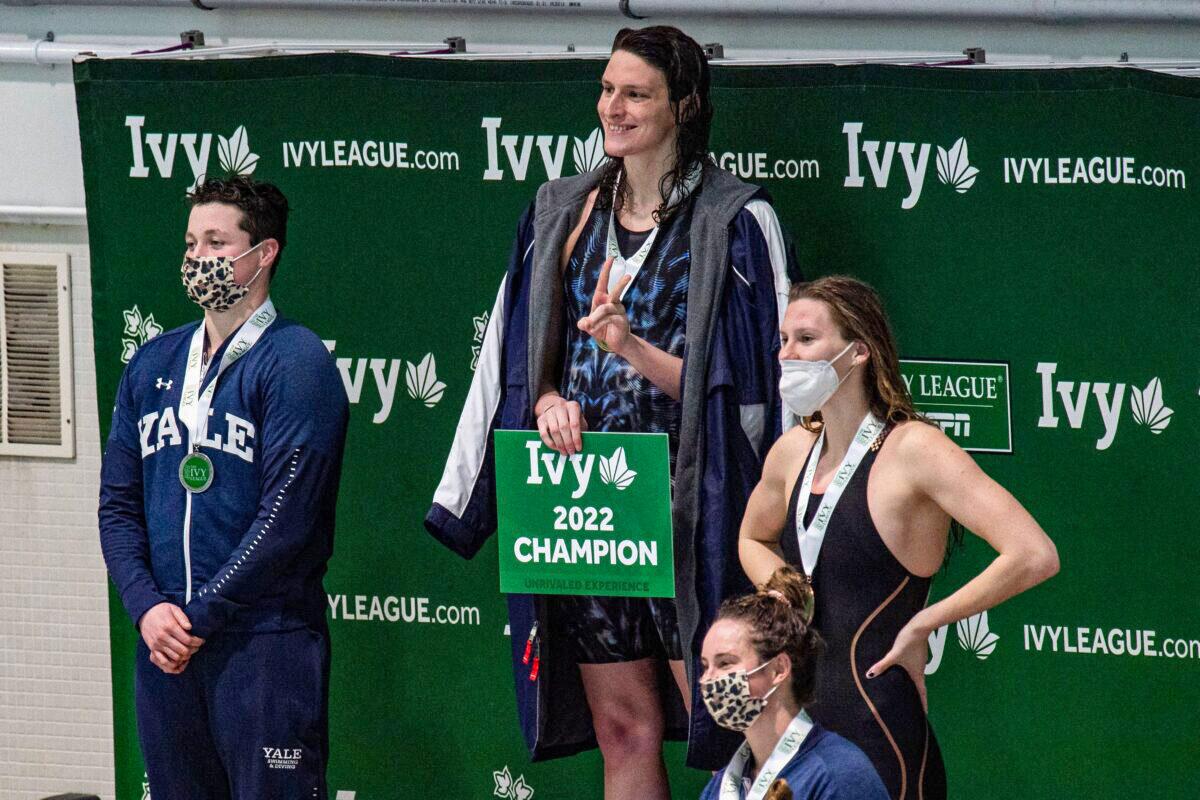 Pennsylvania State University swimmer Lia Thomas (2nd L)—a male who identifies as female—and Yale swimmer Iszac Henig (L)—a female who identifies as male—pose with their medals after placing first and second in the 100-yard freestyle swimming race at the 2022 Ivy League Women's Swimming & Diving Championships at Harvard University in Cambridge, Mass., on Feb. 19, 2022. (Joseph Prezioso/Getty Images)