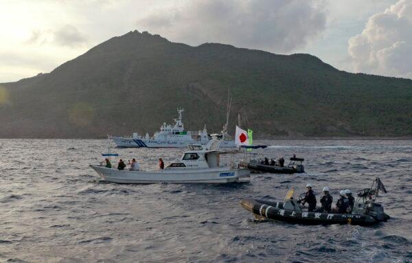 Japanese Coast Guard vessel and boats (rear and right) sail alongside a Japanese activists’ fishing boat (center) near the disputed Senkaku Islands, in the East China Sea, on Aug. 18, 2013. (Emily Wang/AP Photo)