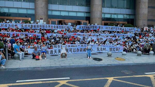 People hold banners and chant slogans during a protest at the entrance to a branch of China's central bank in Zhengzhou in central China's Henan Province, on July 10, 2022. (Yang/AP Photo)