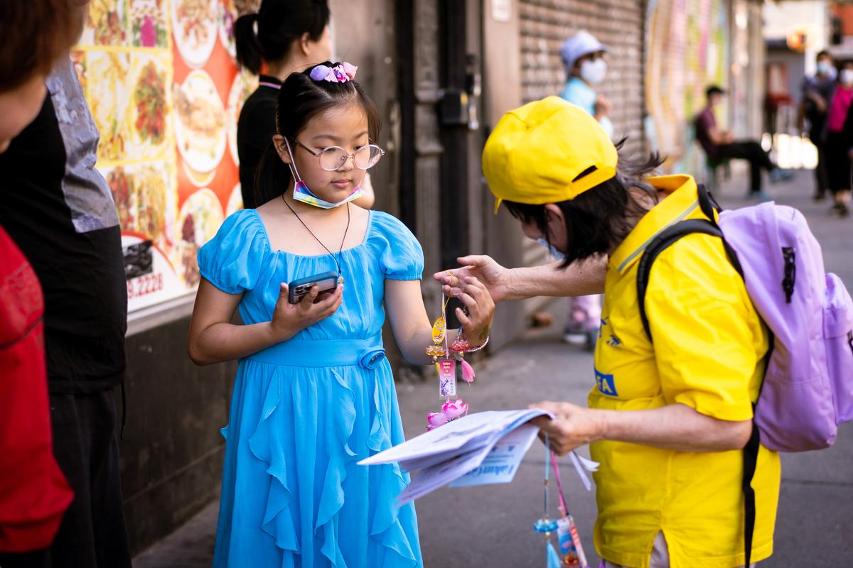 Falun Gong practitioners take part in a parade to commemorate the 23rd anniversary of the persecution of the spiritual discipline in China, in New York's Chinatown on July 10, 2022. (Samira Bouaou/The Epoch Times)