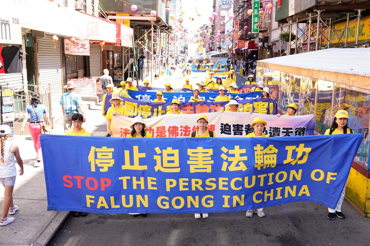 Falun Gong practitioners take part in a parade to commemorate the 23rd anniversary of the persecution of the spiritual discipline in China, in New York's Chinatown on July 10, 2022. (Larry Dye/The Epoch Times)