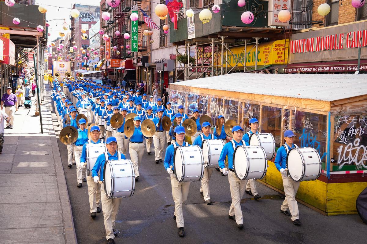 Falun Gong practitioners take part in a parade to commemorate the 23rd anniversary of the persecution of the spiritual discipline in China, in New York's Chinatown on July 10, 2022. (Larry Dye/The Epoch Times)
