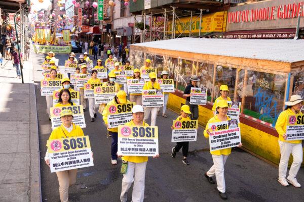 Falun Gong practitioners take part in a parade to commemorate the 23rd anniversary of the persecution of the spiritual discipline in China, in New York's Chinatown on July 10, 2022. (Larry Dye/The Epoch Times)