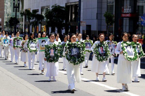 People hold flower wreaths with photos of Falun Gong practitioners who were persecuted to death by the Chinese Communist Party in China, during a parade in San Francisco on July 16, 2022. (Cynthia Cai/The Epoch Times)