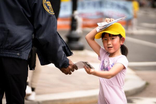 Falun Gong practitioners march down Pennsylvania Avenue to commemorate the 23rd anniversary of the Chinese Communist Party's persecution of the spiritual practice in China, in Washington on July 21, 2022. (Samira Bouaou/The Epoch Times)