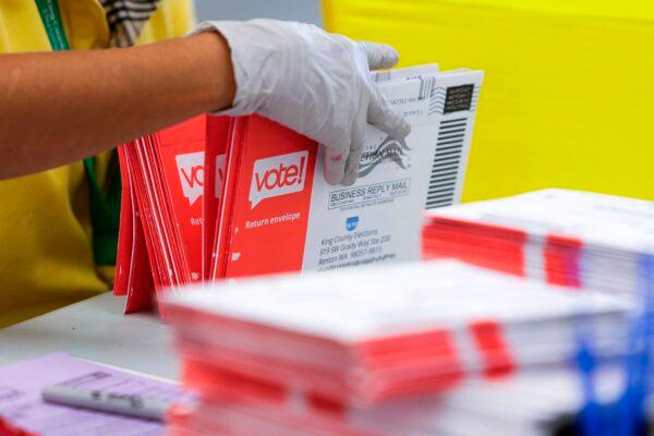 An election worker opens envelopes containing vote-by-mail ballots for the Aug. 4 Washington state primary at King County Elections in Renton, Washington on Aug. 3, 2020. (Jason Redmond/AFP via Getty Images)