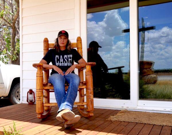 Sheila Payne Blackburn sits on her front porch overlooking her 2,000-acre ranch in Cross Plains, Texas, on Aug. 9, 2022. After losing her father to COVID-19, Blackburn is now facing financial hardship due to extreme drought gripping much of the state. (Allan Stein/The Epoch Times)