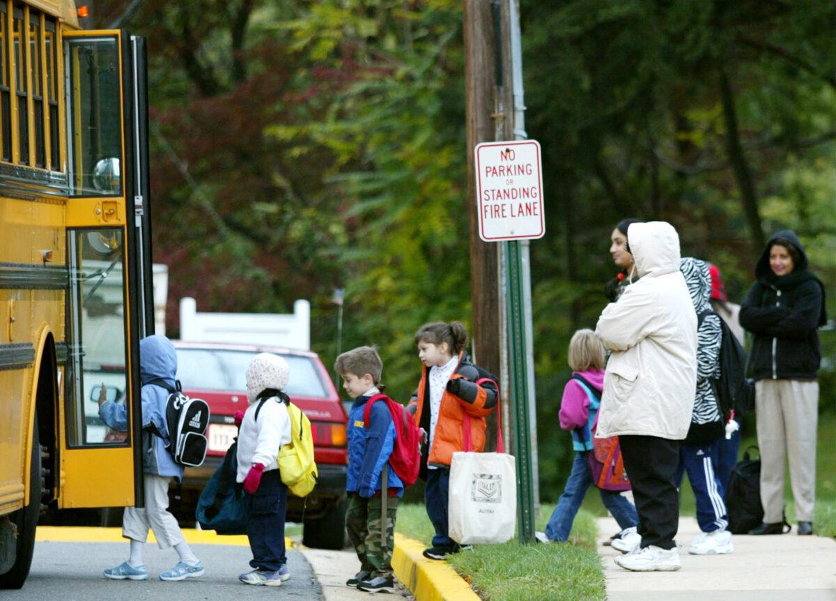 Parents watch children step onto a Fairfax County school bus in Falls Church, Va., on Oct. 15, 2002. (Mark Wilson/Getty Images)