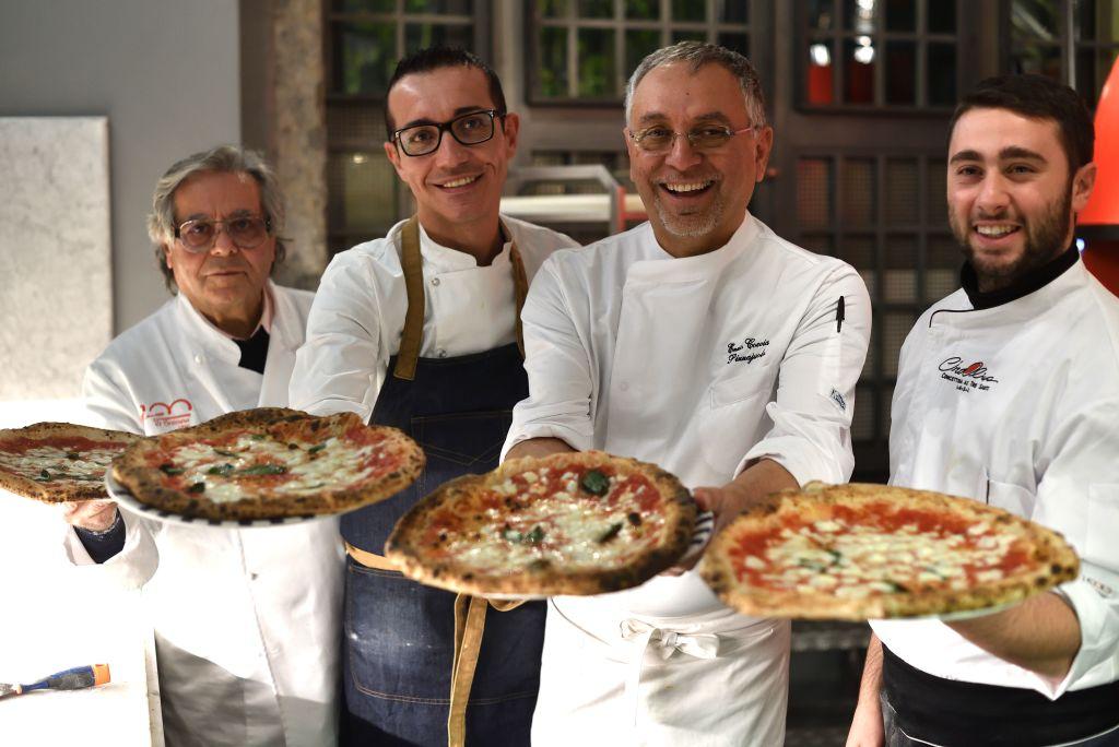 (L–R) Neapolitan pizza-makers Antonio Starita, Gino Sorbillo, Enzo Coccia, and Ciro Oliva pose with pizzas in Naples, Italy, on Dec. 6, 2017. UNESCO said on Dec. 7, 2017, that the art of the Neapolitan "Pizzaiuolo" (pizza-maker) has been put on its prestigious Intangible Cultural Heritage list. (Tiziana Fabi/AFP via Getty Images)