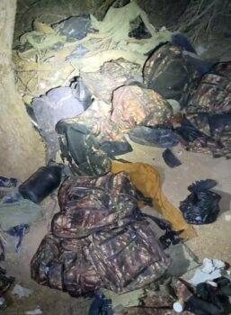 Discarded camouflage backpacks lie in a pile near a section of border fencing in Arizona recently. (Courtesy photo)