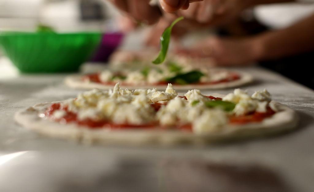 A pizza-maker prepares a pizza at the pizzeria Sorbillo in Naples, Italy, on Dec. 6, 2017. UNESCO said on Dec. 7, 2017, that the art of the Neapolitan "Pizzaiuolo" (pizza-maker) has been put on its prestigious Intangible Cultural Heritage list. The art of the Neapolitan Pizzaiuolo is a culinary practice consisting of four different phases relating to the preparation of the dough and its baking in a wood-fired oven. The practice originates in Naples, where about 3,000 Pizzaiuoli now live and perform, and plays a key role in fostering social gatherings and intergenerational exchange. (Tiziana Fabi/AFP via Getty Images)
