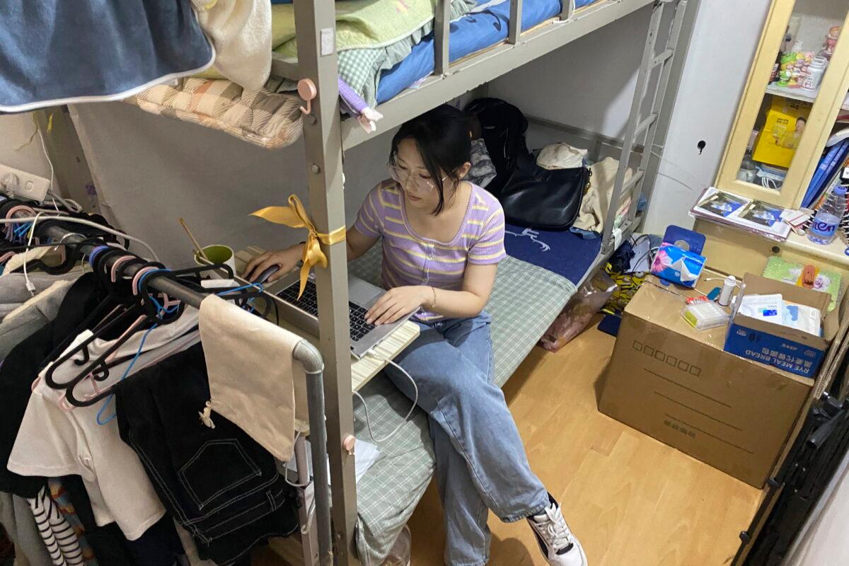 Recent college graduate Liu Qian works on her laptop computer in the room she rents in an apartment in Beijing on July 7, 2022. (Olivia Zhang/AP Photo)