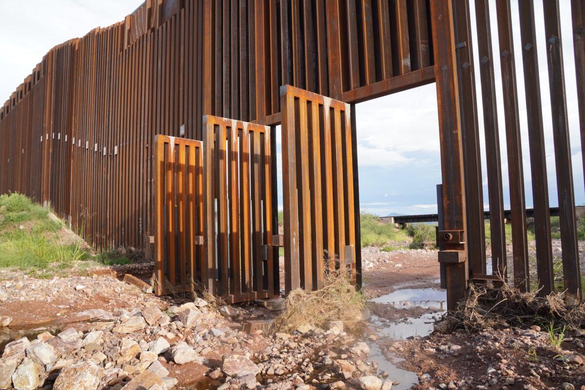 Open floodgates provide easy access for illegal aliens crossing into the United States from Mexico along the southern border wall fence in Douglas, Ariz., on Aug. 24, 2022. (Allan Stein/The Epoch Times)