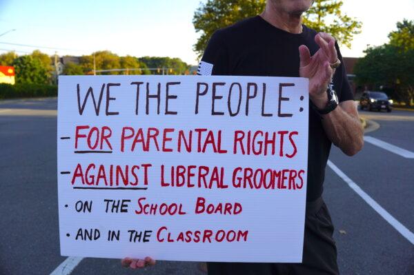 A protester outside Luther Jackson Middle School in Falls Church, Va., before a Fairfax County Public Schools board meeting on Sept. 15, 2022. (Terri Wu/The Epoch Times)