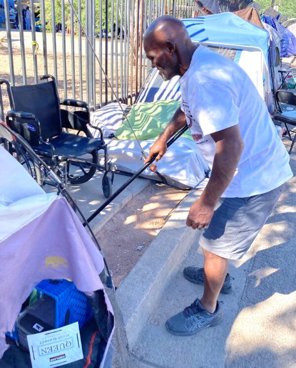 Clarence Carter, 65, walks around his tent keeping it clean on Sept. 18. Carter has been living in The Zone, a homeless encampment in Phoenix, Ariz., since November after his wife died. (Allan Stein/The Epoch Times)