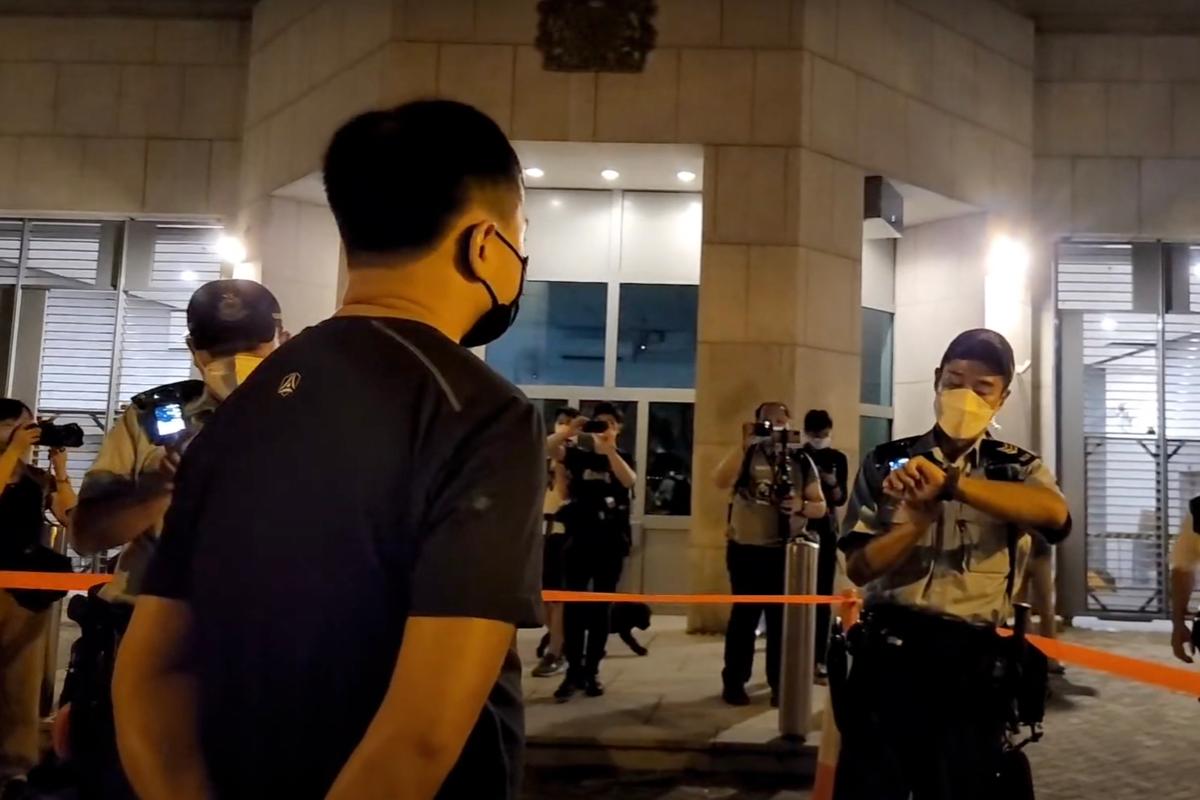 Police took into custody a man who was playing the British anthem with his harmonica outside the British Consulate General in Hong Kong on Sept. 19, 2022. (Doris Li/The Epoch Times)