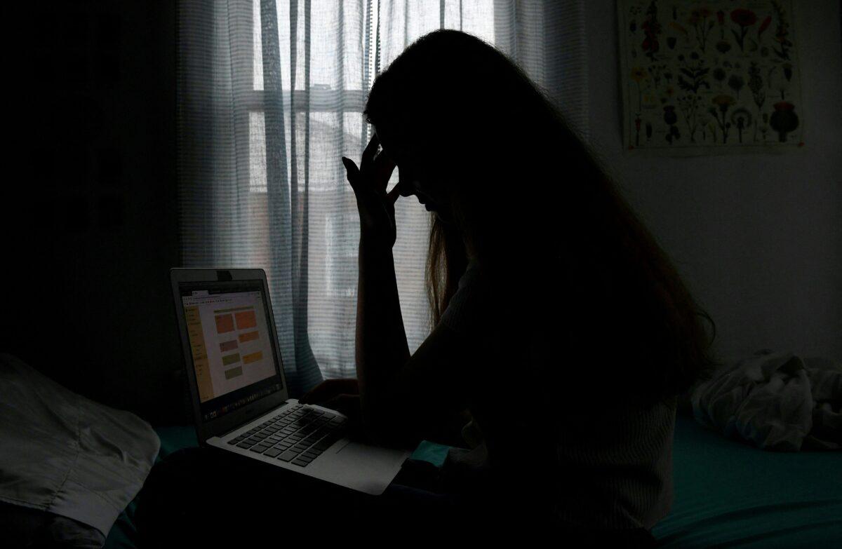 A teenager with a laptop in Arlington, Va., on June 11, 2021. (Olivier Douliery/AFP via Getty Images)