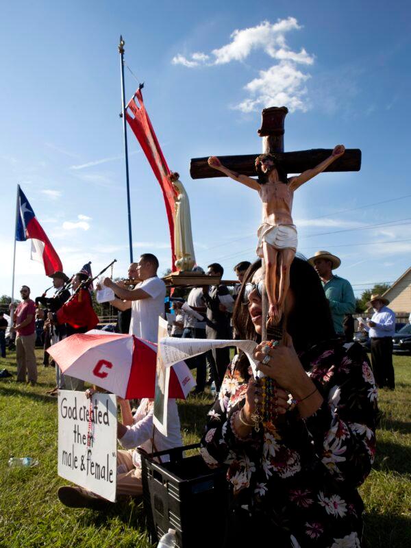 Laura Austria prays across the street from a pro-LGBT church on Sept. 24, 2022. (Bobby Sanchez for The Epoch Times)