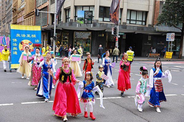 The photo shows Falun Gong practitioners from Queensland wearing traditional and ethnic costumes in the procession. (Xu Shengkun/The Epoch Times)