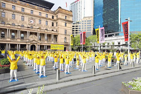 Falun Gong practitioners from across Australia marched in Sydney to call on the Australian government to help stop the persecution of Falun Gong by the CCP. The photo shows practitioners doing Falun Gong exercises in front of the Customs House (Xu Shengkun/The Epoch Times)