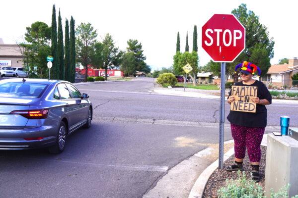 Woneta Odem-Thompson, formerly of Nevada, holds a sign asking for help near the front entrance to a retail strip mall in Cottonwood, Ariz., on Oct. 3. (Allan Stein/The Epoch Times)