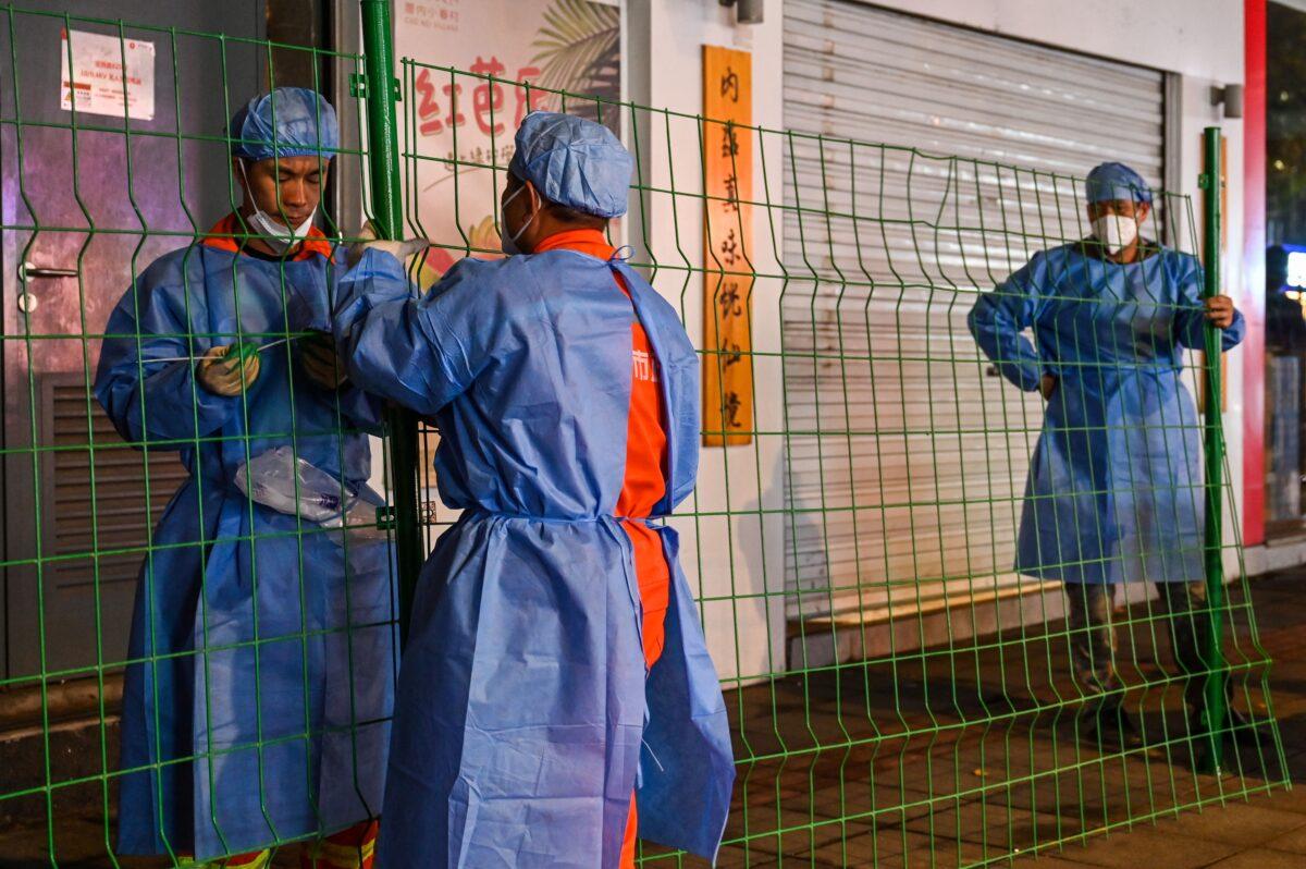 Workers erect fencing around a neighbourhood in lockdown in Shanghai's Changning district after new COVID-19 cases were reported on Oct. 7, 2022. (Hector Retamal/AFP via Getty Images)